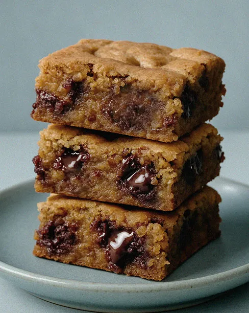 Stack of chocolate chip dessert bars on a plate.